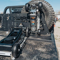 Load image into Gallery viewer, Black 3-ton Badlands Pro Eagle jack with rugged wheels mounted on truck bed, spare tire in background.