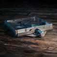 Load image into Gallery viewer, Metallic Starlink Mini Mount with adjustable clamp on dark wooden surface.