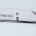 Load image into Gallery viewer, Close-up of large silver aluminum mount with precision cut holes and engraved partial text.
