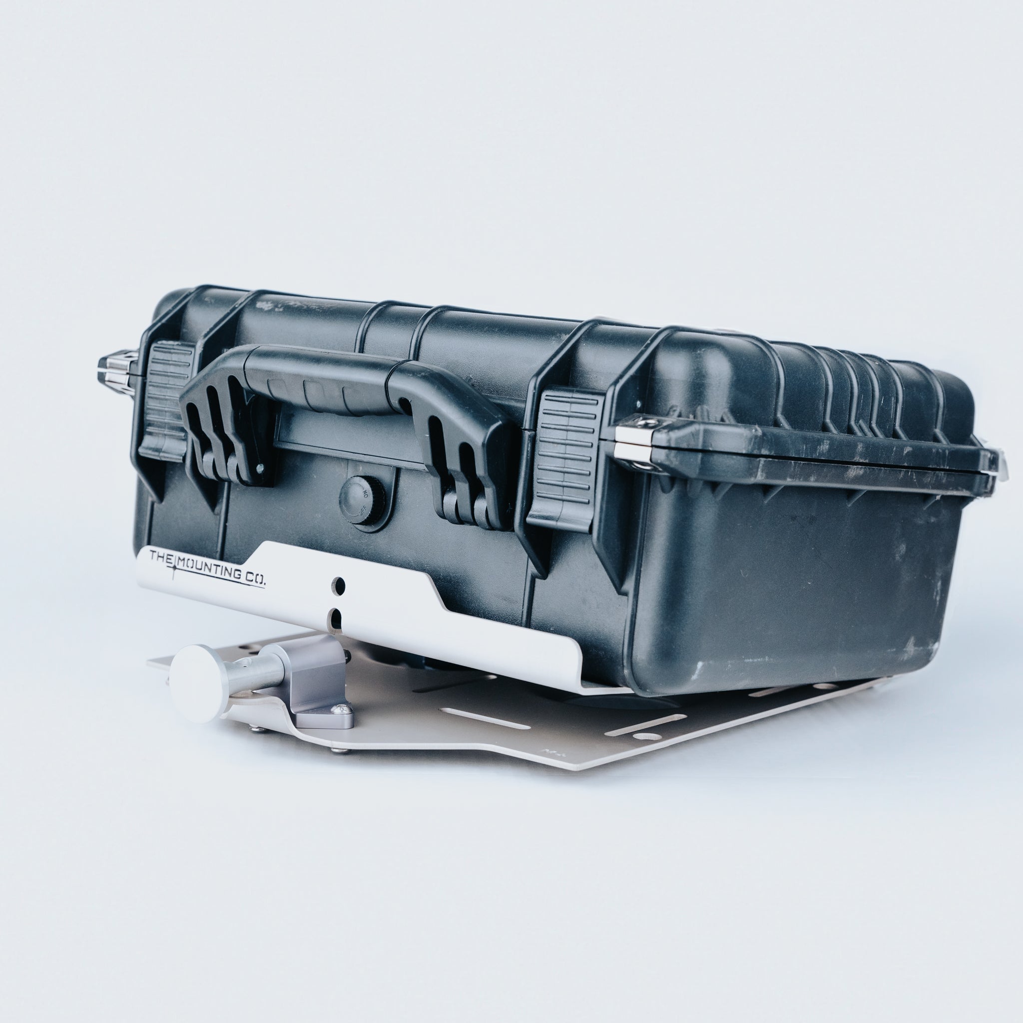 Black rugged hard case mounted on a silver aluminum quick-release bracket with latches.